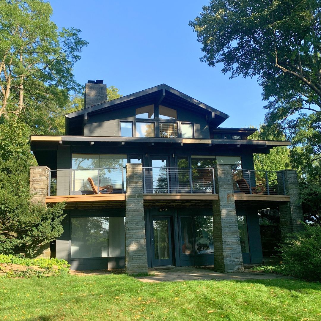 Modern house retreat in lush greenery with striking architecture and spacious balcony for relaxation.