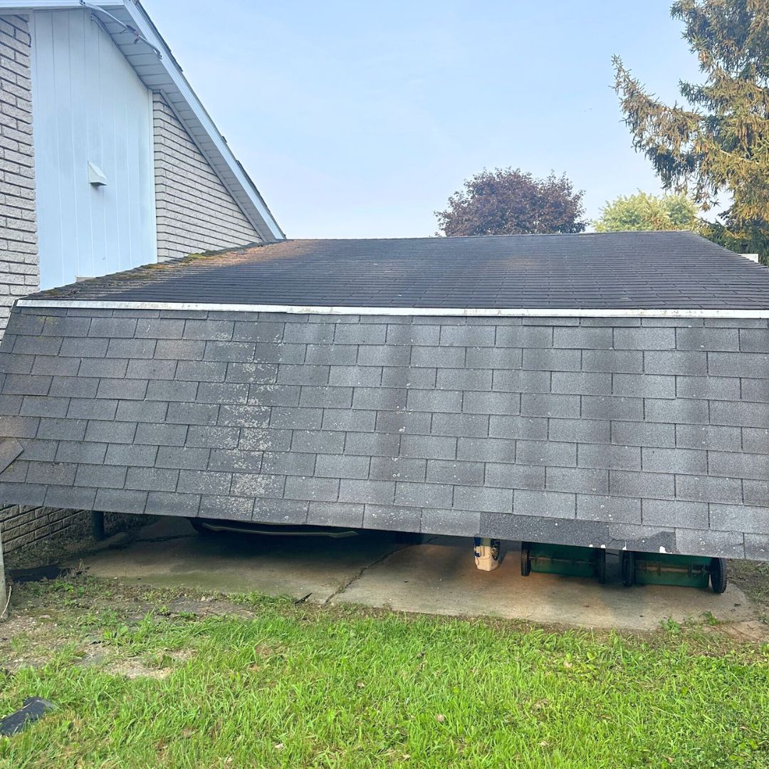 Unique garage with sagging roof and green lawn in a charming neighborhood with roofing details.