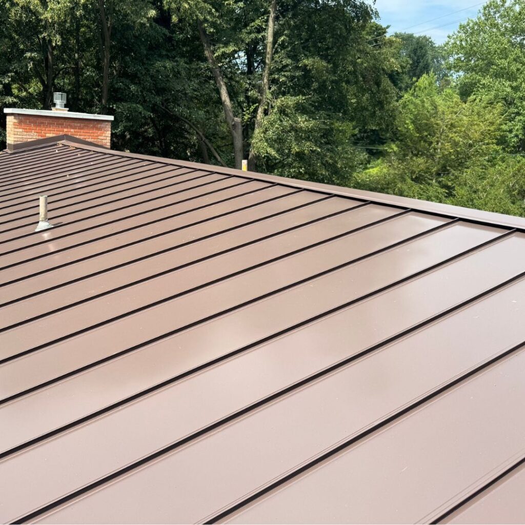 Contemporary Neighborhood Roofing features a sleek brown seamless standing seam metal Roof.