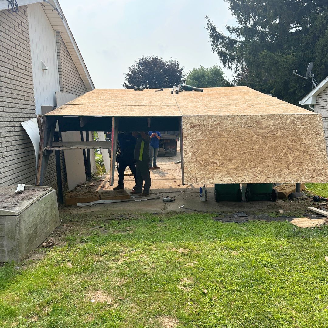 Neighborhood Roofing construction scene with workers building an extension next to a brick building.