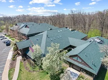 Neighborhood Roofing building complex set in a serene, natural landscape with vibrant landscaping.